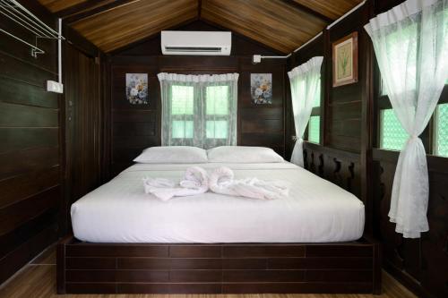 a bedroom with a bed with two pink bows on it at Cenanghill Beachfront in Pantai Cenang
