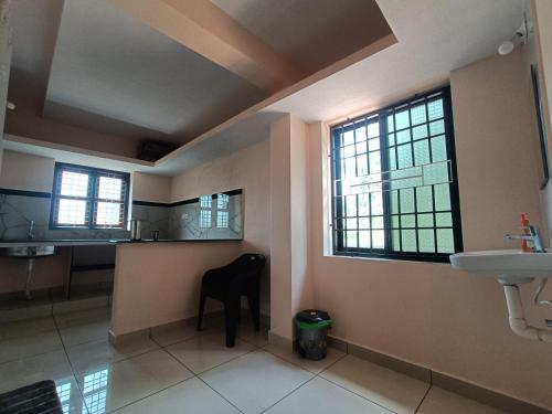 a bathroom with a black chair and a sink at Gokula Arcade in Subrahmanya