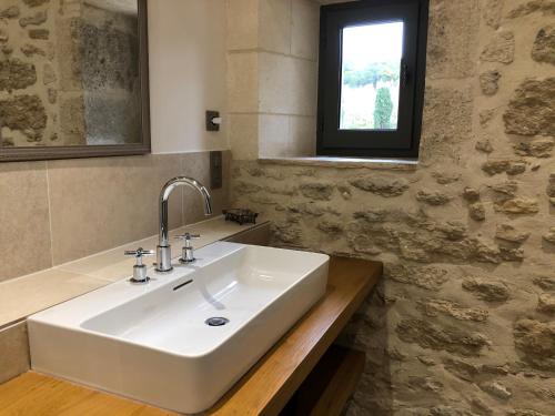 a white sink in a bathroom with a window at Moulin de Carrière, dans un parc de 2 hectares à Uzès in Uzès