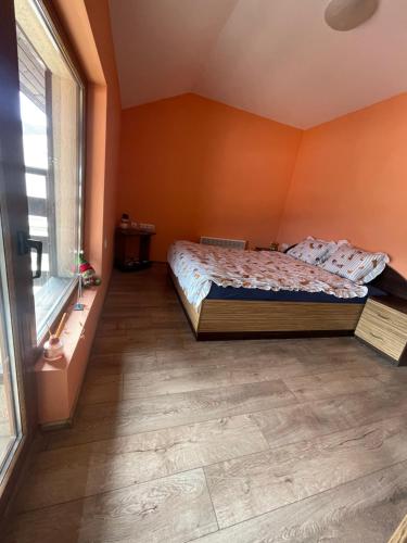 a bedroom with a bed and a large window at Планинска ЗВЕЗДА in Chepelare