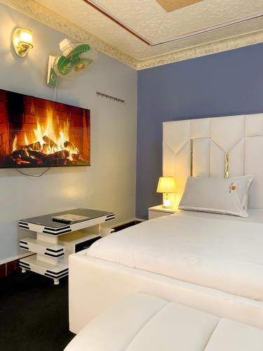 a bedroom with a bed and a fireplace at Royal Lake View Gardens in Kampala