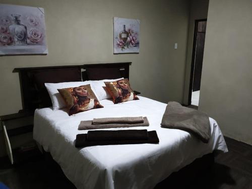 a bedroom with a bed with towels on it at Palmnut Lodge in Durban