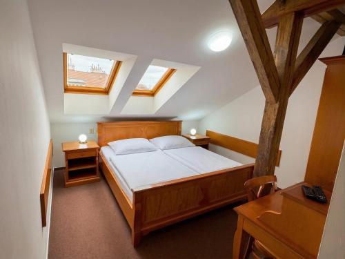 a bedroom with a bed and two tables and a window at Brezina Pension in Prague