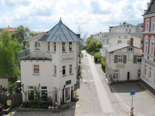 a white building with a black roof on a street at Villa Am Steinbach in Sassnitz