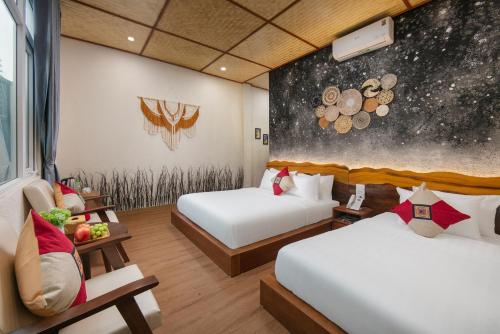 a hotel room with two beds and a painting on the wall at Wanderlust Staycation in Hanoi