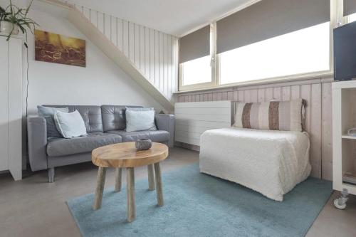 a living room with a couch and a table at Appartement Zuid 5 strand op 2 minuten lopen in Zandvoort