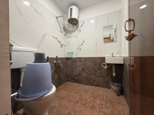 a bathroom with a blue toilet and a sink at Teja Residency in Alāndurai