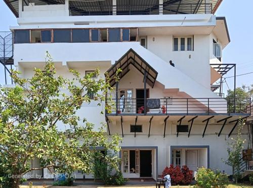 a white building with a balcony on top of it at Coorg rest house in Madikeri