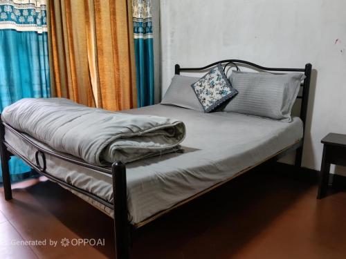 a bed with a blanket and pillows on it at Coorg rest house in Madikeri