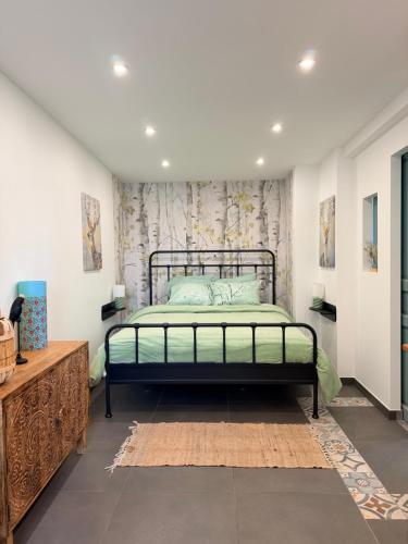 a bedroom with a bed with a green bedspread at Au bord de l'étang in Saint-Aubin