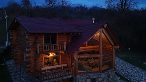 a log cabin with a large window at night at Nomad Escape Bran in Sohodol
