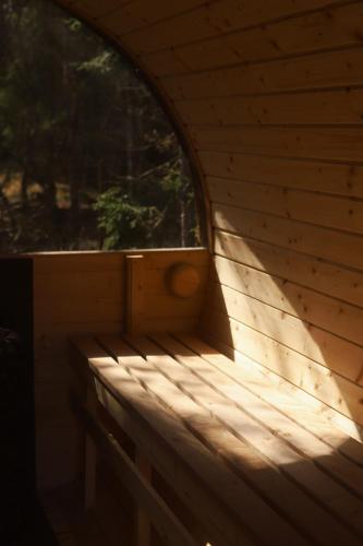 a wooden room with a window and a wooden bench at Dom przy Lesie z sauną in Augustów