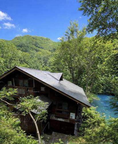 a cabin in the woods next to a river at WEND URABANDAI -the private villa- in Kitashiobara