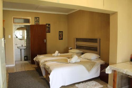 a bedroom with three beds and a sink at Ruacana Guest House in Ruacana