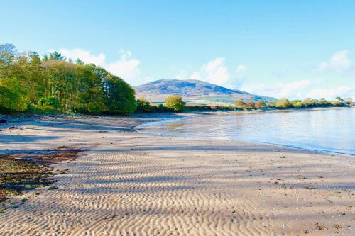 a view of a beach with a mountain in the background at Little Dunbar in Dumfries