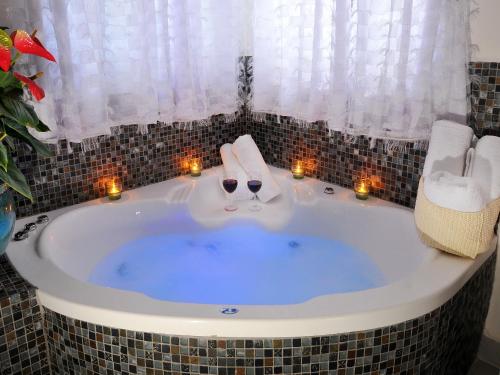 a jacuzzi tub with candles in a bathroom at Gal Golan Suites in Had Nes