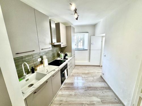 a white kitchen with a sink and a stove at Laglio Cloud Nine, Como Lake in Laglio