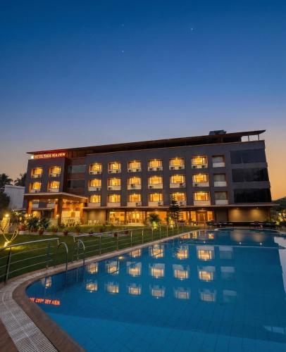 a hotel with a swimming pool in front of a building at Hotel Tania Searock in Daman