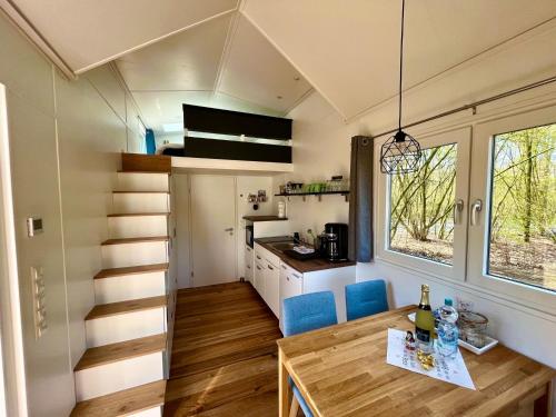 a tiny house with a dining table and a kitchen at Kleines Ems-Idyll in Lathen