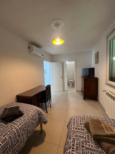 a bedroom with two beds and a desk and a table at Villa Luigia in Gerenzano