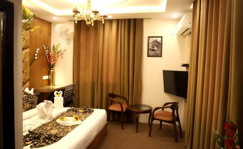 a hotel room with a bed and a table and chairs at The Hoften Al Shaykh Resorts, Srinagar in Srinagar