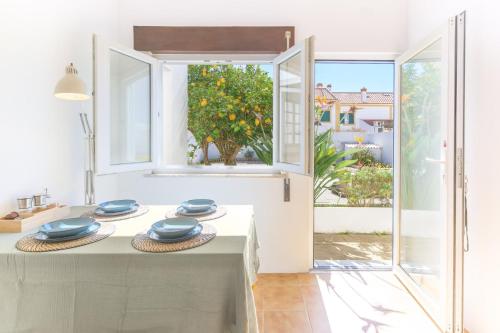 a kitchen with an open window and blue dishes on a counter at Casa Bettina in Vila Nova de Milfontes