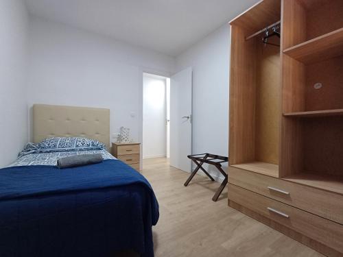 a bedroom with a blue bed and a dresser at Carbo Home y Garaje , Algemesí Home in Algemesí