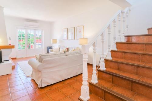 a living room with a couch and stairs at Casa Buganvília in Sines