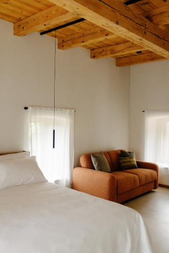 a bedroom with a bed and a couch at La Ghiandaia Farmhouse in Conegliano