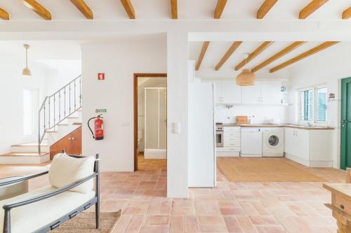 a kitchen with white walls and wooden ceilings at Casa Sol Limão in Zambujeira do Mar