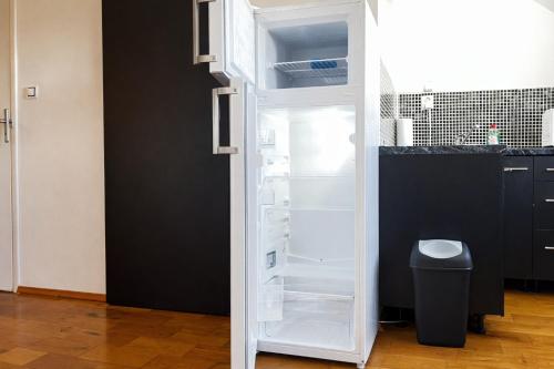 an empty refrigerator with its door open in a kitchen at Symbiola River Apartments in Děčín