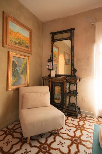 a living room with a chair and a mirror at Maison de l'Arte di Bà in San Nicola Arcella