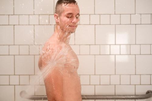 a man is standing in a shower with water at Brit Hotel Du Ban in Chaudes-Aigues