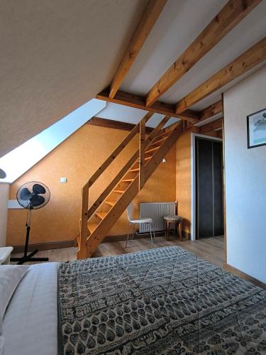 a bedroom with a loft with a staircase and a bed at Hotel De France in Pontorson