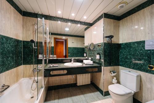 a bathroom with a tub and a toilet and a sink at Abba Fonseca in Salamanca