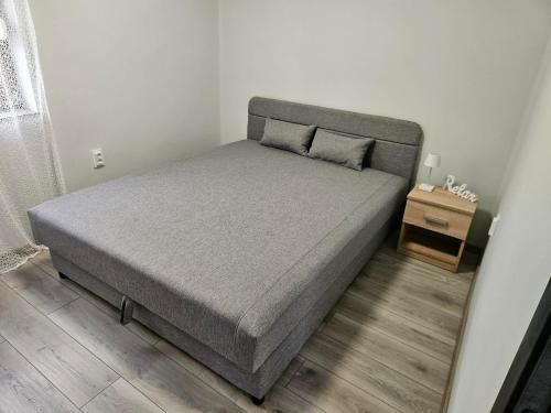 a bed in a small bedroom with a night stand at Dream vendégház in Vásárosnamény
