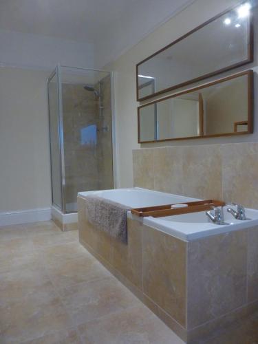 a bathroom with a tub and a shower and a sink at Mersey View, Two Bedroom Apartment, Liverpool in Waterloo
