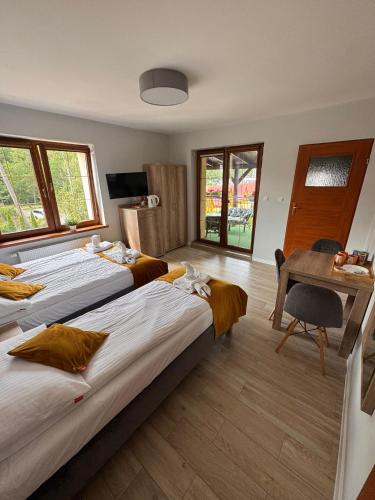 a hotel room with two beds and a desk at SUN & WINE in Pobierowo
