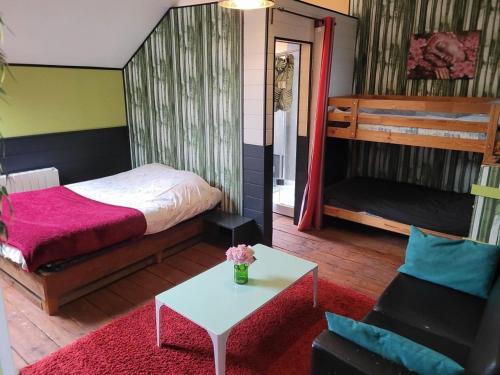 sypialnia z łóżkiem, stołem i kanapą w obiekcie chambre zen w mieście Condé-sur-Noireau