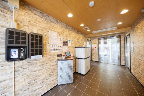 a kitchen with a refrigerator and a counter in a room at New Normal Condo in KENCHOMINAMIGUCHI ニューノーマルコンドイン県庁南口 in Naha