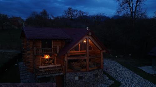 a small log cabin with a window at night at Nomad Escape Bran in Sohodol