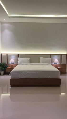 a bedroom with a large white bed with two lamps at Pondok Wahyu in Ubud