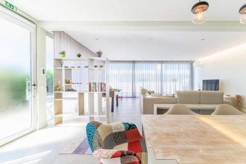 a living room with a table and a dining room at Vila Praia Grande in Sines