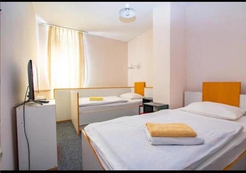 ein Zimmer mit zwei Betten und einem Schreibtisch mit Fernseher in der Unterkunft Hotel Split in Glamoč
