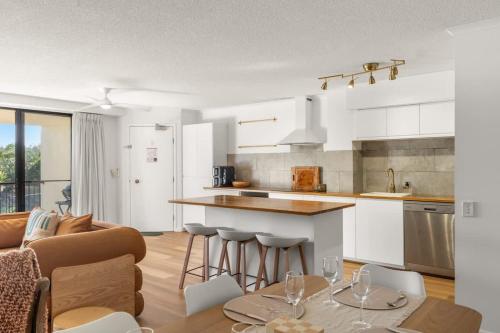 a kitchen and living room with a table and chairs at Coastal Drift - Beach Access Pool Spa Gym in Marcoola