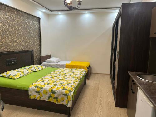 two beds in a small room with a sink at cosy house in Kobuleti