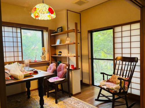 a room with a desk and a chair and windows at 伊東旅館 禅- Zen - in Ito