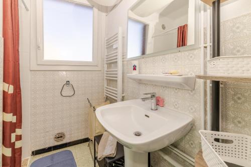 a bathroom with a white sink and a window at Appart cathare et l'olivier in Tautavel