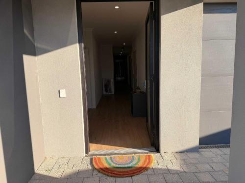 a door to a hallway with a rainbow rug at Modern Karnup House in Karnup