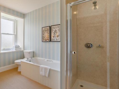 a bathroom with a tub and a toilet and a shower at 3 Bed in Thurso oc-ca337 in Mey